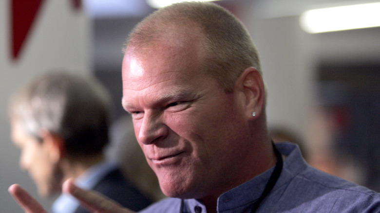 Mike Holmes speaking animatedly to someone and pointing fingers at an event.