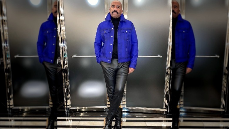 Steve Harvey wearing a blue jacket and black pants