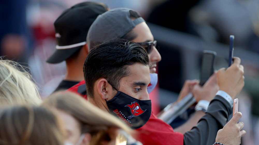Football fans wearing COVID masks