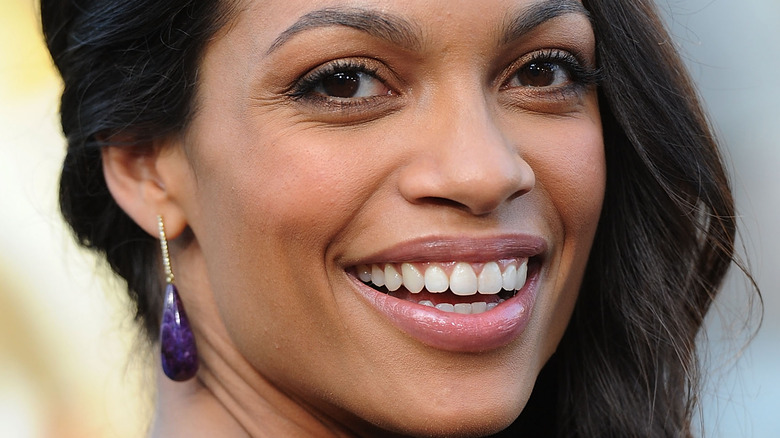 Rosario Dawson smiles over her shoulder