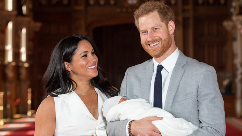 Meghan Markle and Prince Harry smiling holding son Archie