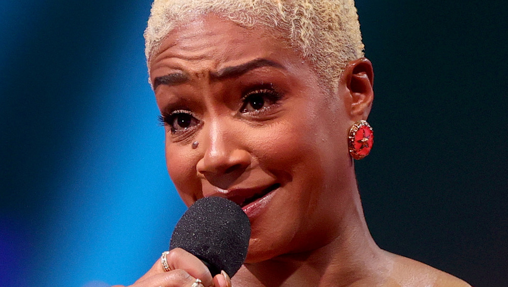 Tiffany Haddish speaking into a microphone on stage