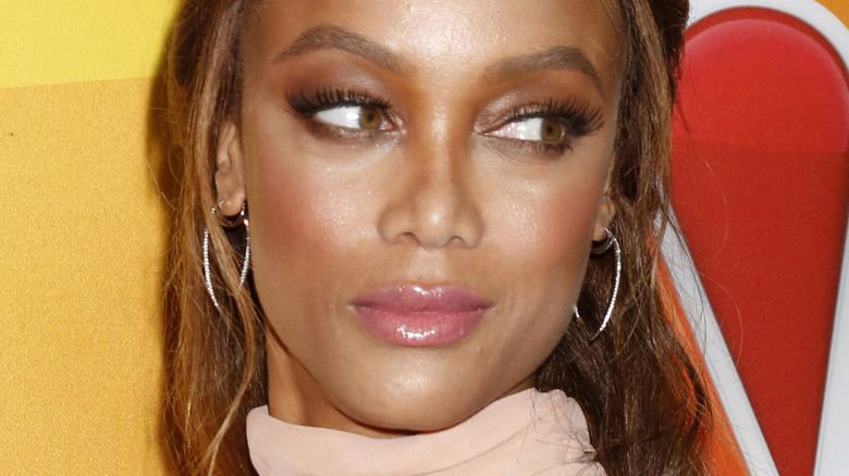 Tyra Banks glancing back over shoulder