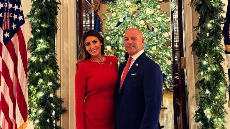 Alina Habba posing with her husband, Gregg Reuben, in front of Christmas decoration