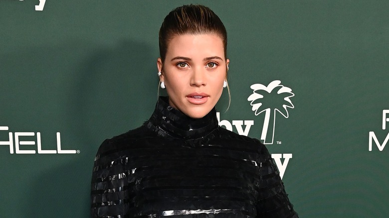 Sofia Richie in shiny black turtleneck dress