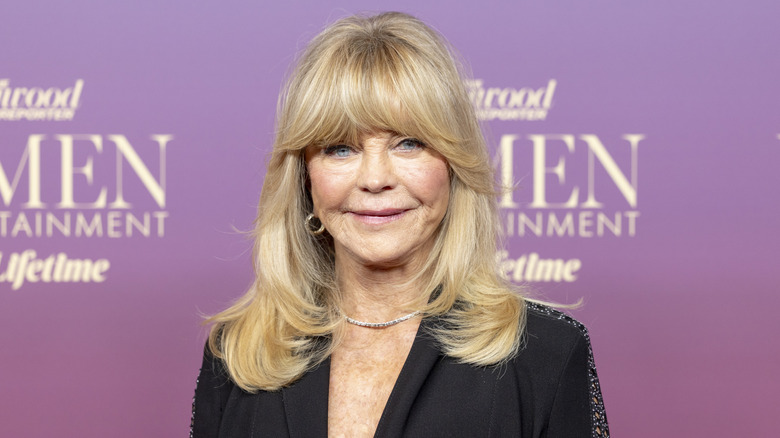 Goldie Hawn smiling in front of a media wall