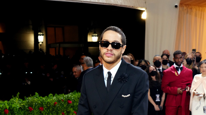 Pete Davidson posing in sunglasses and a suit