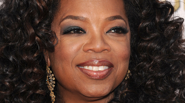Oprah Winfrey smiles in dark eyeshadow.