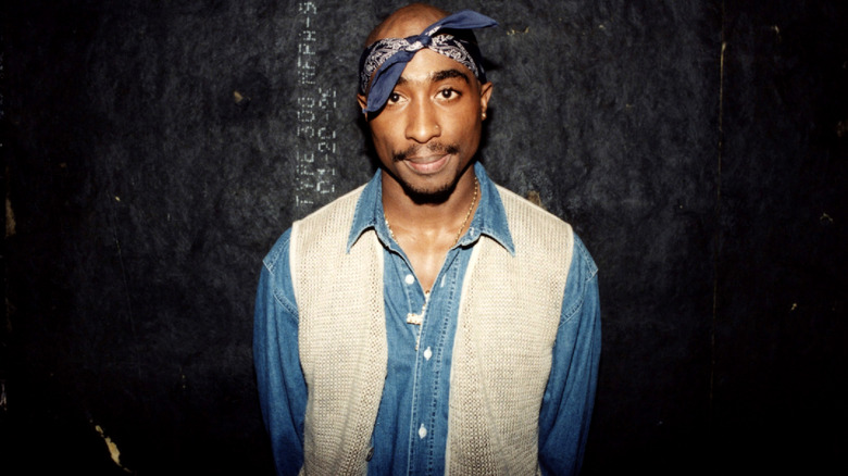 Tupac posing before black wall
