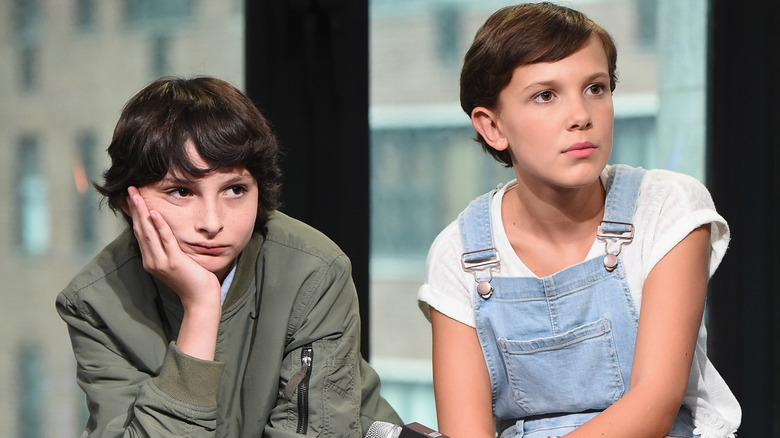 Finn Wolfhard looking glum beside Millie Bobby Brown