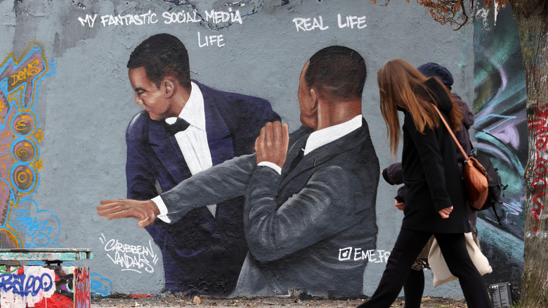 Bypassers look at Will Smith Chris Rock slap public painting