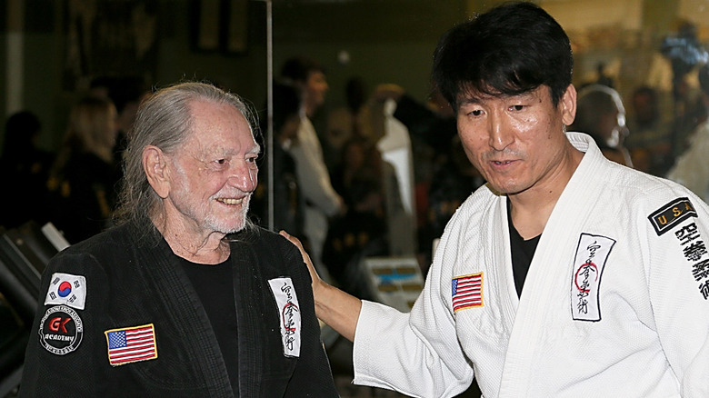 Willie Nelson in a martial arts gi alongside an instructor