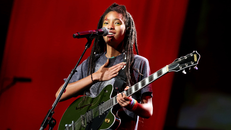 Willow Smith with guitar, hand on chest