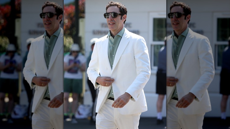 Sacha Baron Cohen walking in white suit at Wimbledon.