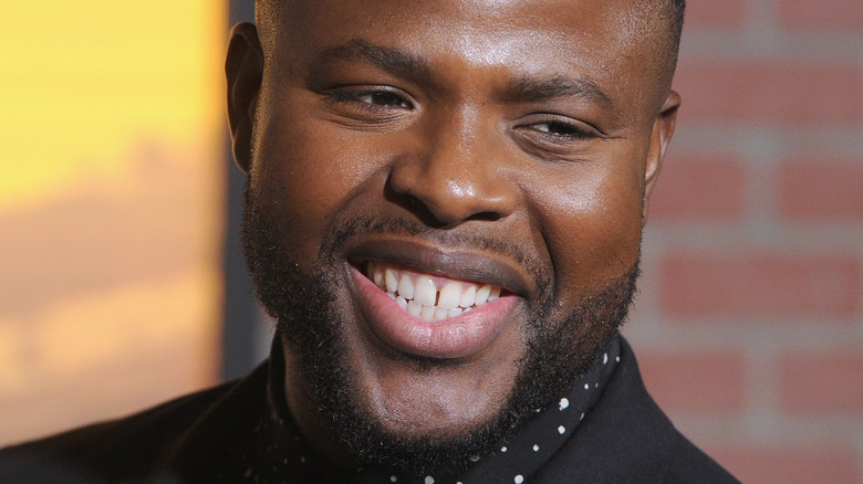 Winston Duke smiling, polka-dot shirt