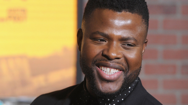 Winston Duke smiling, polka-dot shirt