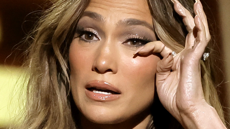 Jennifer Lopez wiping her eye