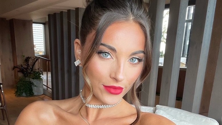 Gianna Tulio taking a selfie while glammed up, wearing a black low-cut gown