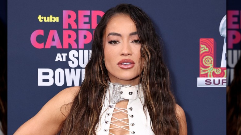 Steph Mi wearing a white lace-up top