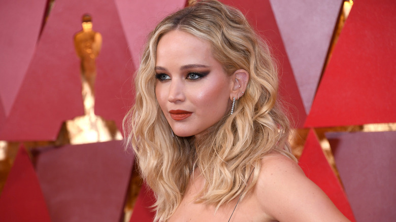 Jennifer Lawrence with wavy blonde hair looking off to the side