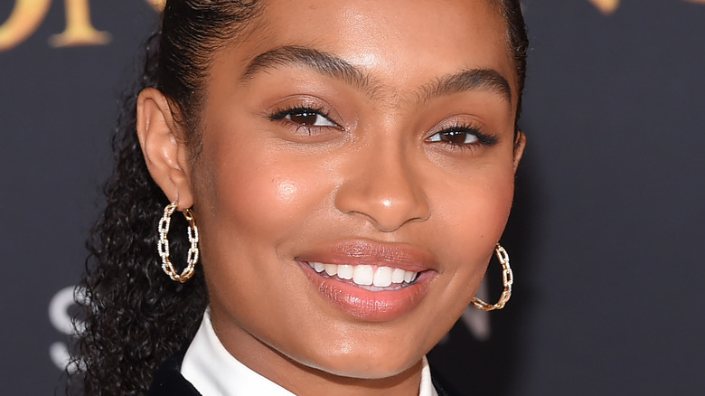 Yara Shahidi wears hoop earrings and a black blazer