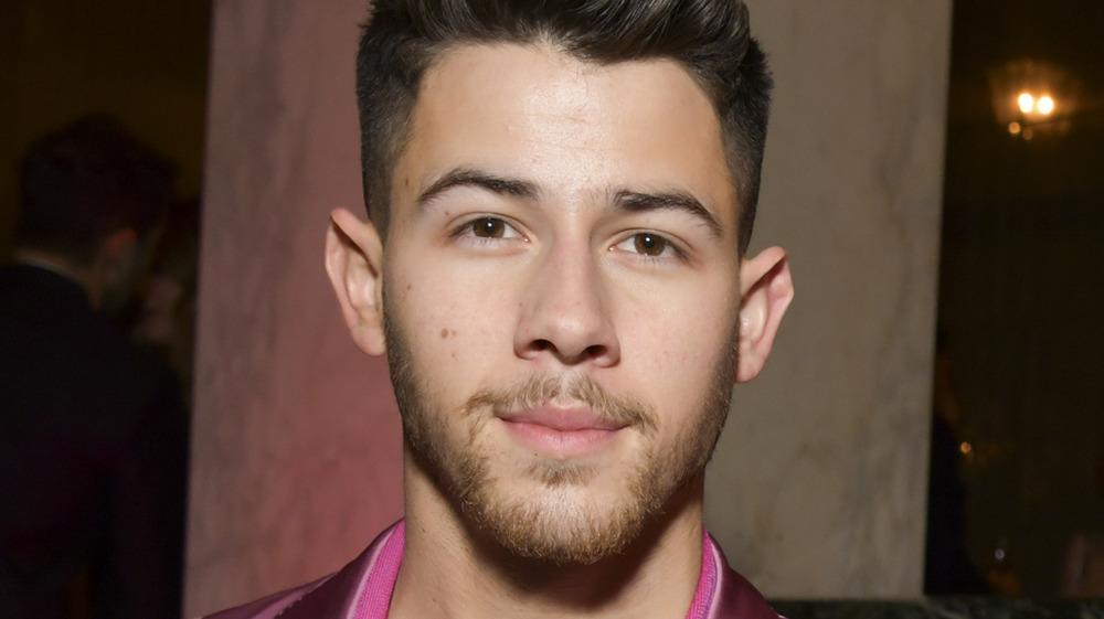 Nick Jonas looking directly into cameras as he poses for pictures