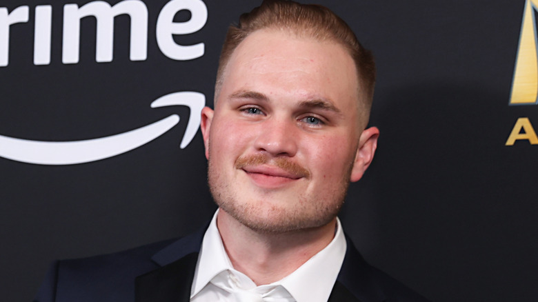 Zach Bryan smirking on red carpet