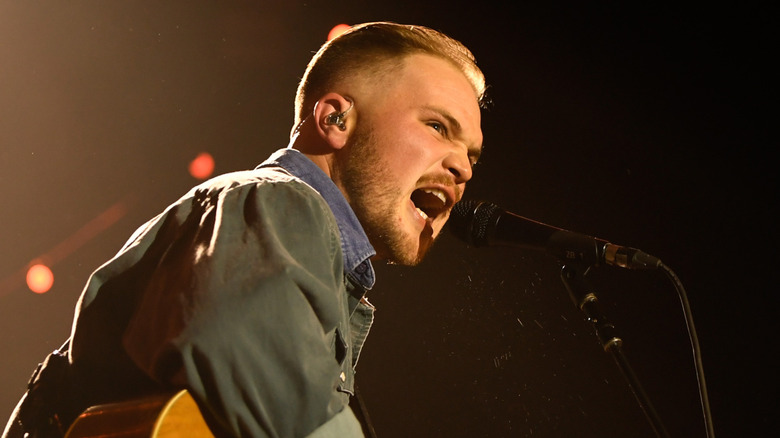 Zach Bryan singing on stage