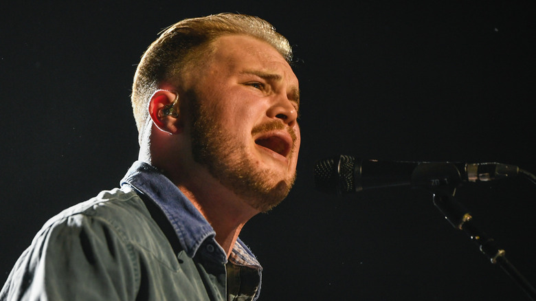 Zach Bryan vocalizing on stage