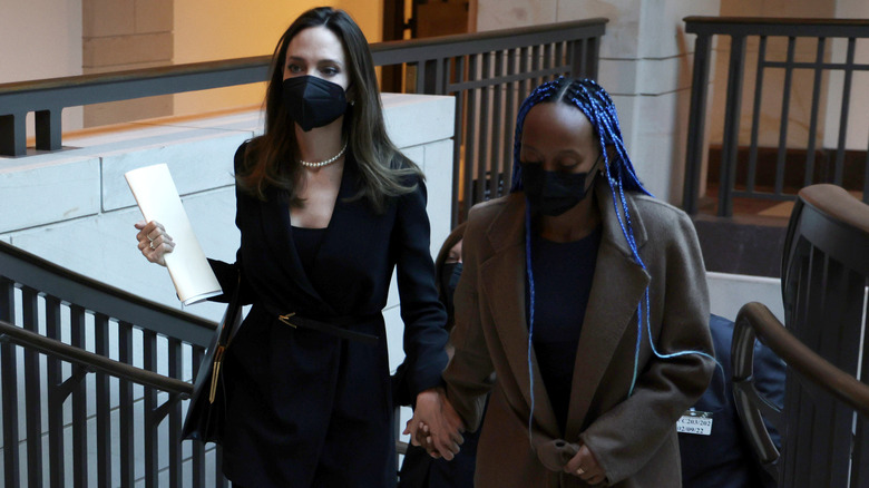 Angelina Jolie holds daughter Zahara's hand up the stairs