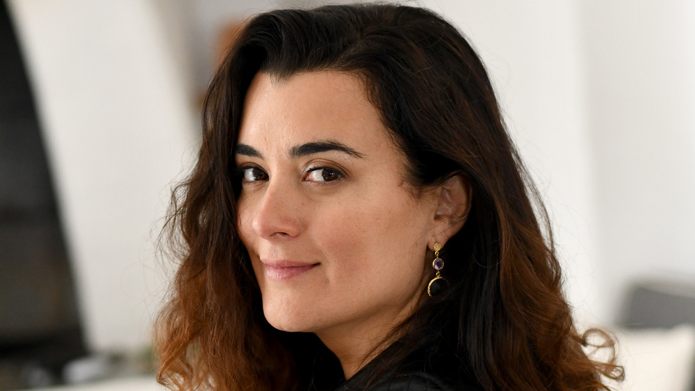 Cote de Pablo smiling while looking back over her shoulder