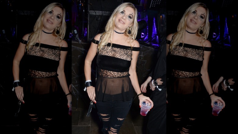Chelsy Davy wearing an all-black Halloween costume consisting of ripped leggings and a semi-sheer top with lace panels