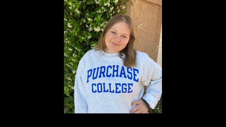 Maura West's daughter Kate posing in a Purchase College sweatshirt.
