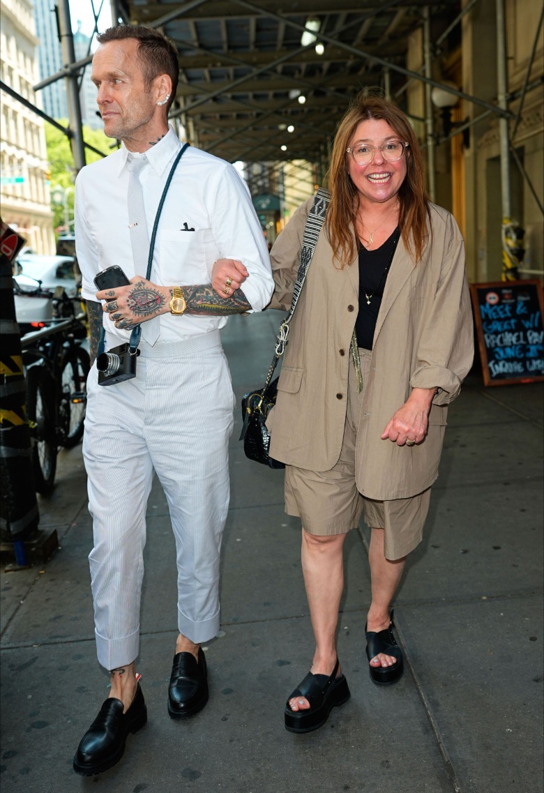 Rachael Ray smiling walking down sidewalk with tattooed photographer