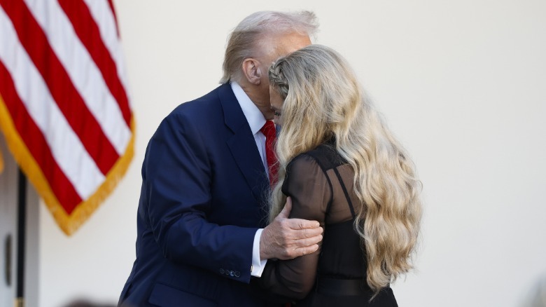 Donald Trump leaning forward and grabbing Erika Kirk's arm during Charlie Kirk's Presidential Medial of Freedom ceremony