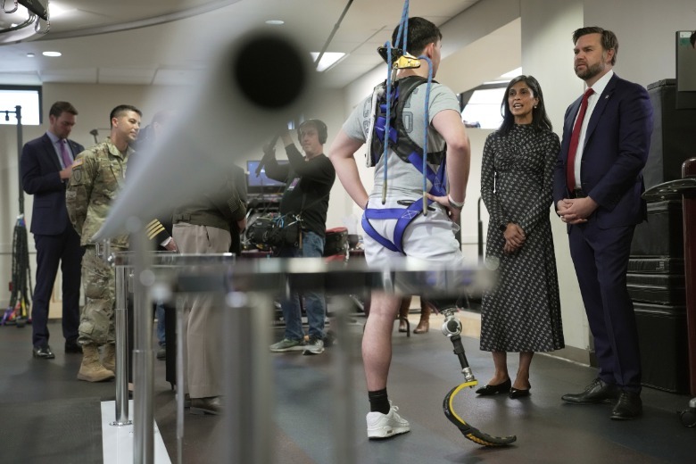 Man in harness speaking to Usha Vance and JD Vance
