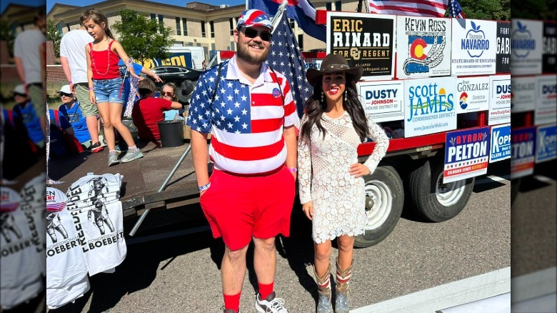 Lauren Boebert wearing lace dress and posing with parade attendee