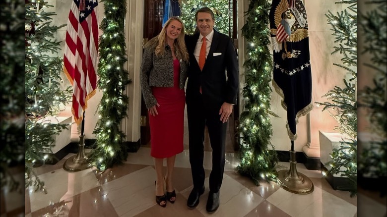 Kristine and Todd Blanche posing next to a Christmas tree