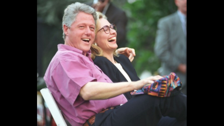 Hillary Clinton and Bill Clinton laughing while seated