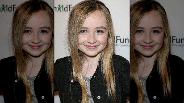 Sabrina Carpenter smiling for cameras on the red carpet.